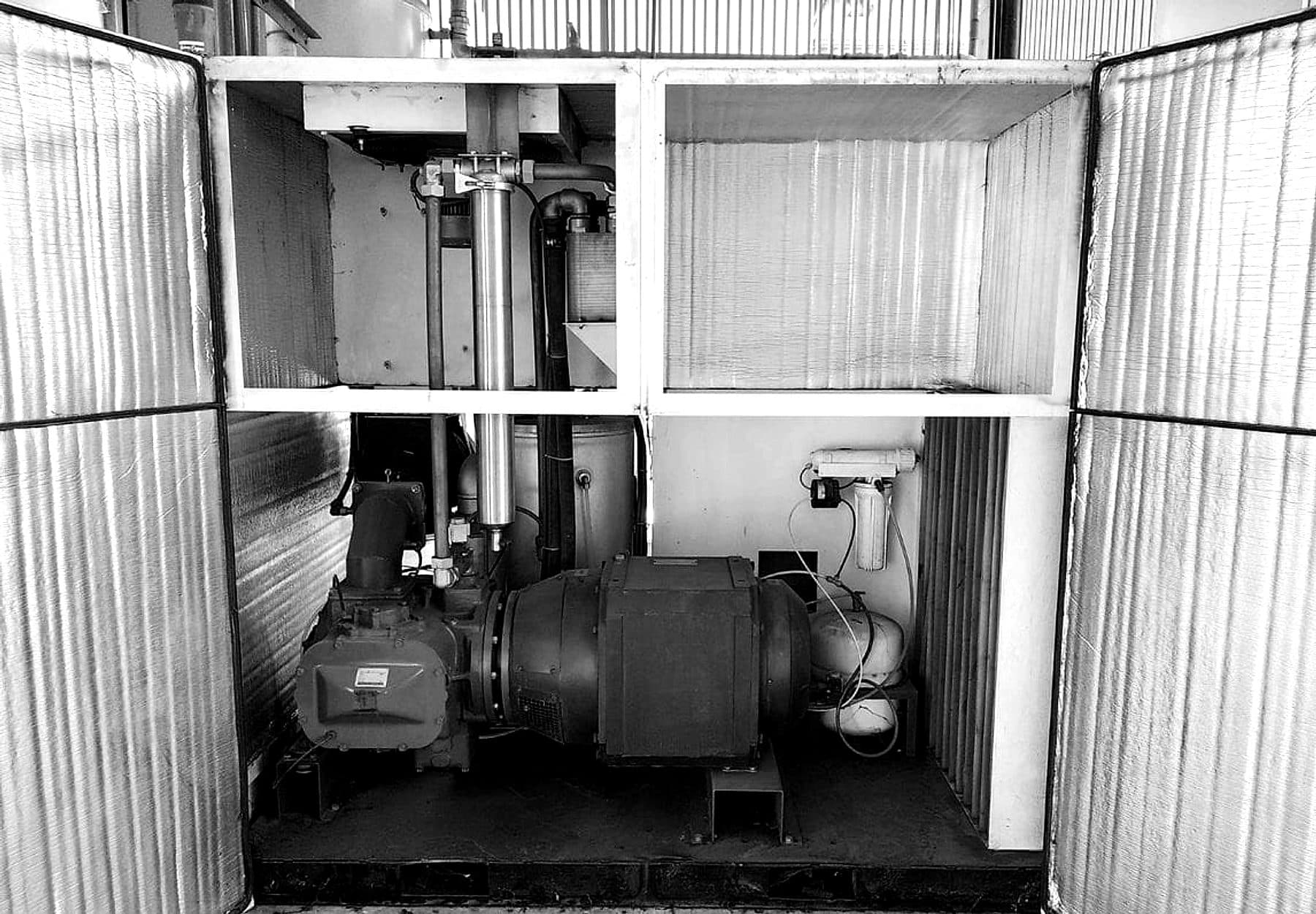 Compresor industrial instalado en planta, con las puertas del gabinete abiertas